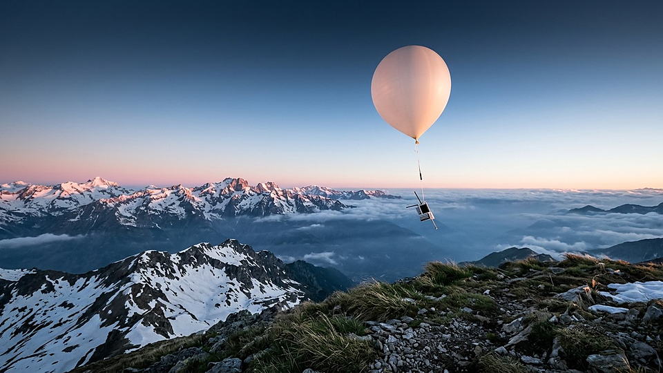 Illustration photoréaliste en lien avec la fiche « L'irradiance solaire reçue au sommet de l'atmosphère. » : Ballon-sonde s'élevant au-dessus d'une mer de nuages vers un ciel qui s'assombrit.