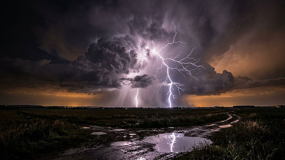 Illustration photoréaliste en lien avec la fiche « La masse totale de l'hydrosphère, c'est-à-dire l'ensemble de l'eau terrestre. » : Orage et éclairs au-dessus d'une chaîne de montagnes.