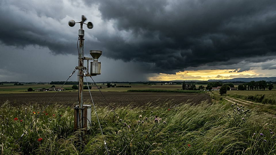 Illustration photoréaliste en lien avec la fiche « La pression atmosphérique moyenne à la surface. » : Station météo de campagne sous un ciel d'orage qui écrase le paysage.